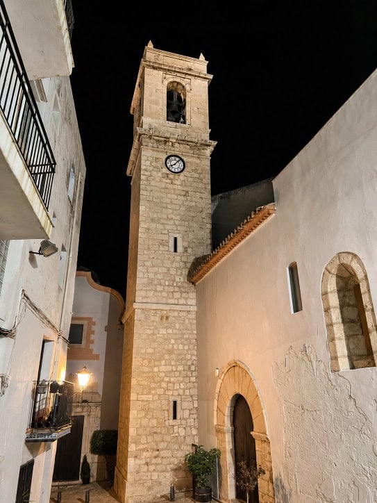 Torre de la iglesia en Peñíscola con reloj y campanario.