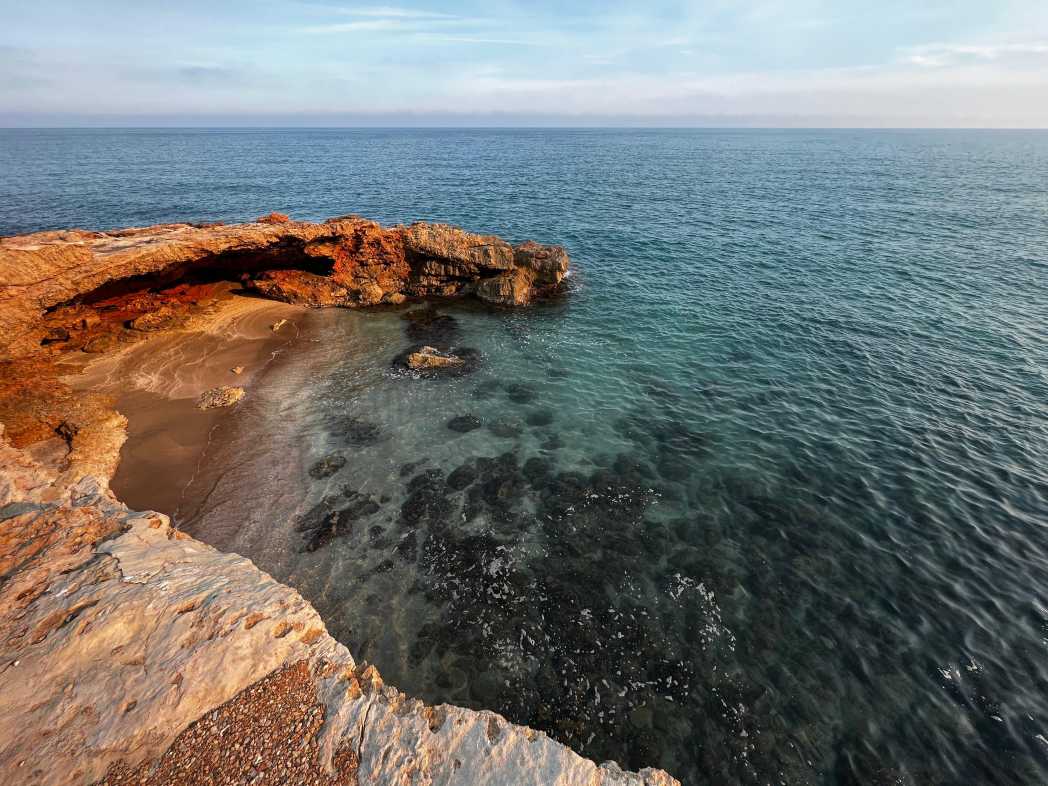 Vista de Cala Badum con rocas y agua cristalina en Peñíscola.
